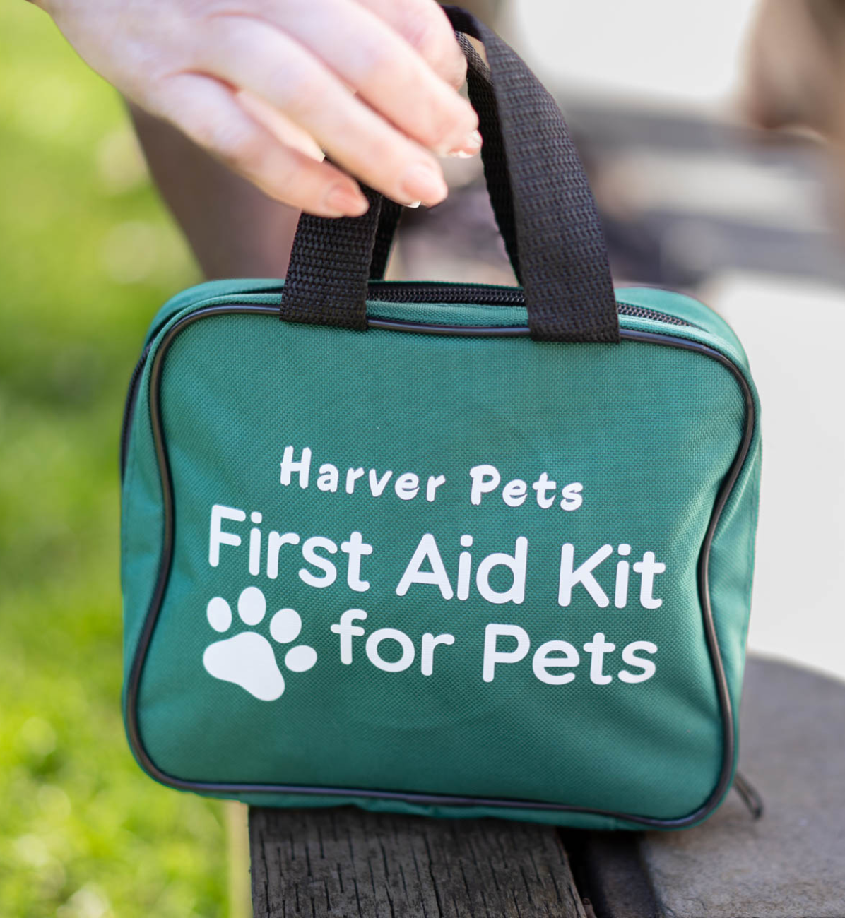 Green first aid kit for pets with 'Harver Pets' branding on a blurred natural background